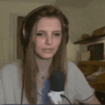 a woman wearing headphones and a microphone is holding a bird in her hand .