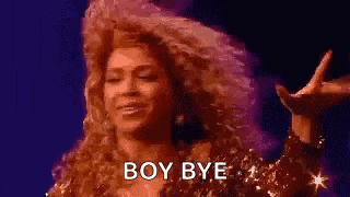 a woman with curly hair is saying `` boy bye '' while standing on a stage .