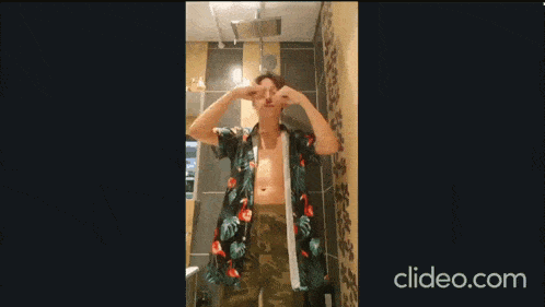 a young boy is dancing in a bathroom with clideo.com written on the bottom