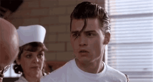 a man in a white shirt and a nurse in a white hat are standing next to each other in a kitchen .