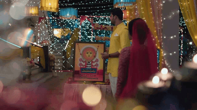 a man in a yellow shirt is pointing at a picture that says ' aa ' on it