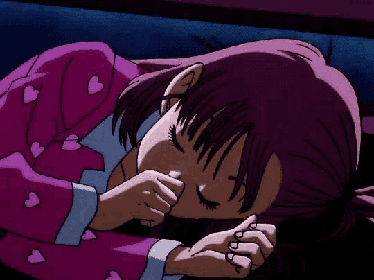 a girl with purple hair is sleeping in a pink pajama with hearts on it