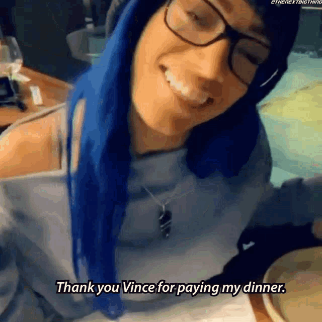 a woman with blue hair and glasses is smiling and says thank you vince for paying my dinner
