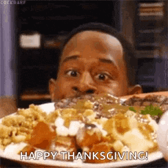 a man is eating a plate of food with the words `` happy thanksgiving '' written on it .