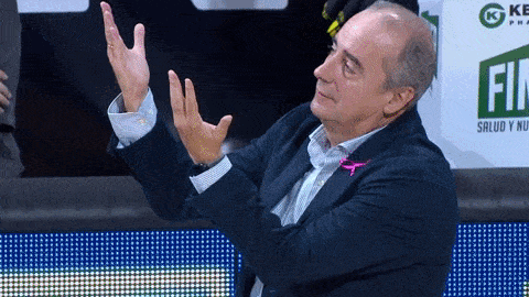 a man in a suit is clapping in front of a sign that says fin