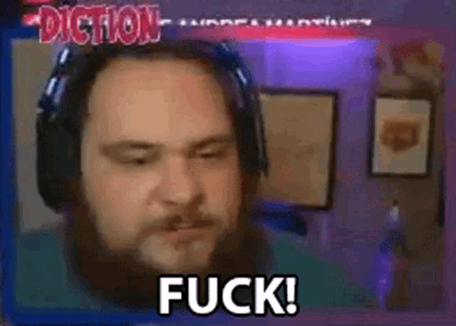 a man with a beard is wearing headphones and says fuck !