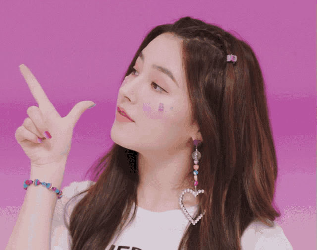 a woman wearing a heart shaped earring and a bracelet with the letter j on it