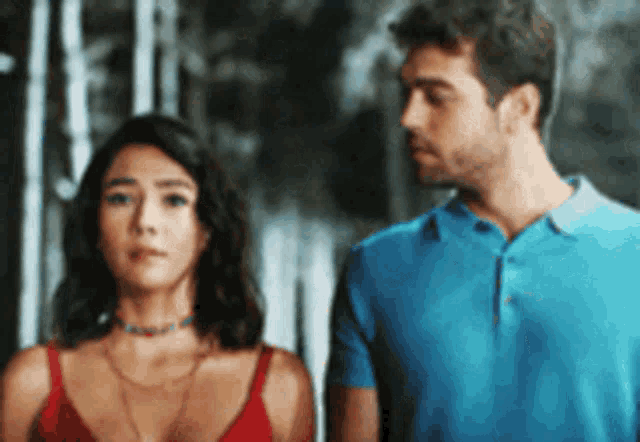 a man and a woman are standing next to each other and looking at each other