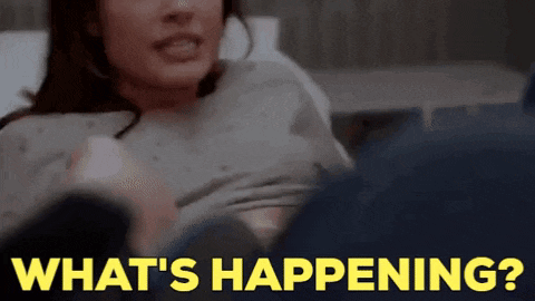 a woman in a hospital gown is holding a baby and asking what 's happening .