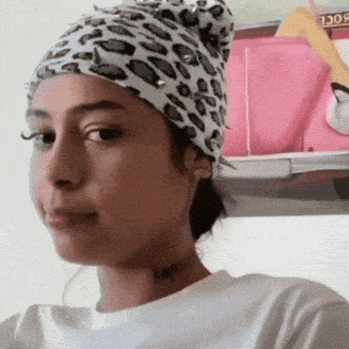 a woman wearing a leopard print headband has a tattoo on her neck that says i love you