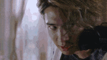 a close up of a young man 's face with a blurred background