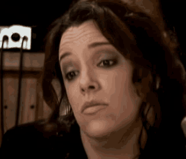 a close up of a woman 's face with a microphone in the background