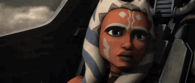 ahsoka tano from star wars is sitting in the cockpit of a fighter jet looking at the camera .