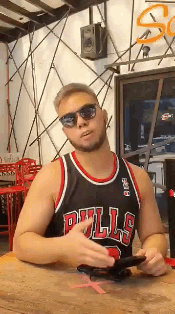 a man wearing a bulls jersey and sunglasses