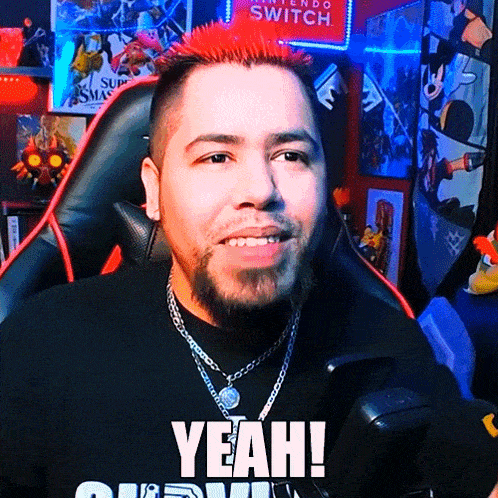 a man with red hair and a beard is sitting in front of a nintendo switch sign