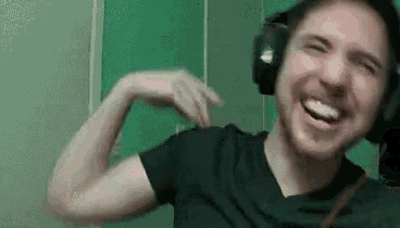a man wearing headphones is flexing his muscles and laughing .