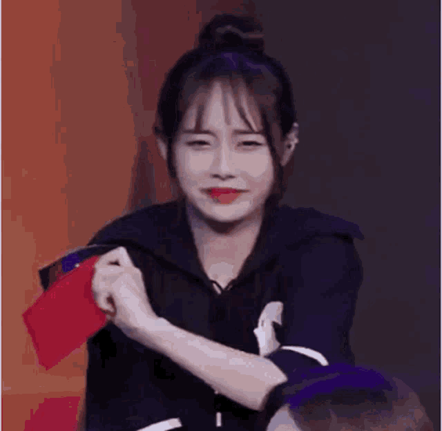 a woman is crying while holding a red wallet in her hand .