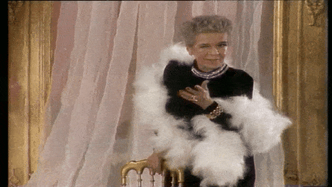 a woman wearing a black dress and a white boa