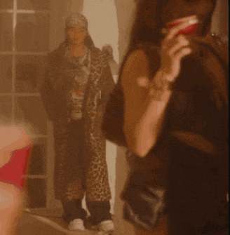 a woman holding a red cup with a leopard print coat in the background