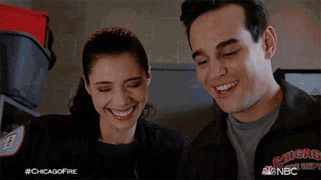 a man and a woman are smiling and wearing a jacket that says chicago fire department