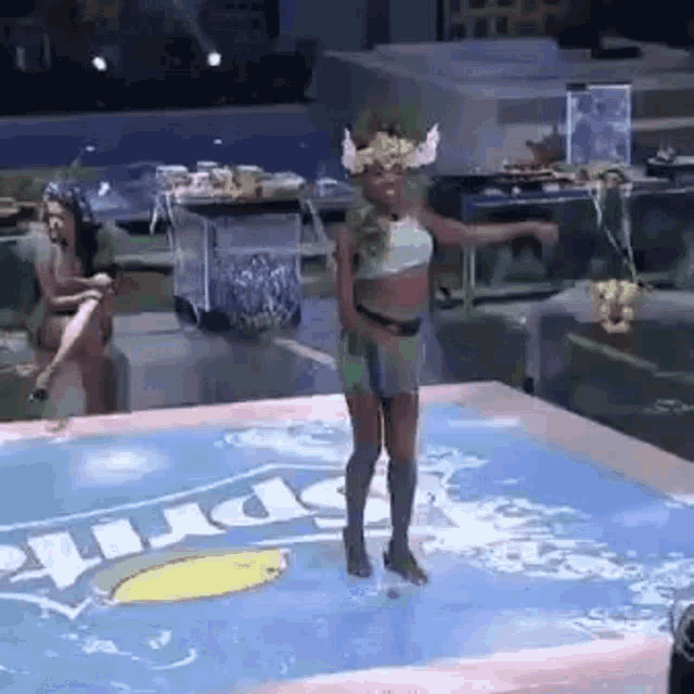 a woman in a viking costume is dancing in a pool with a sprite logo on the floor .