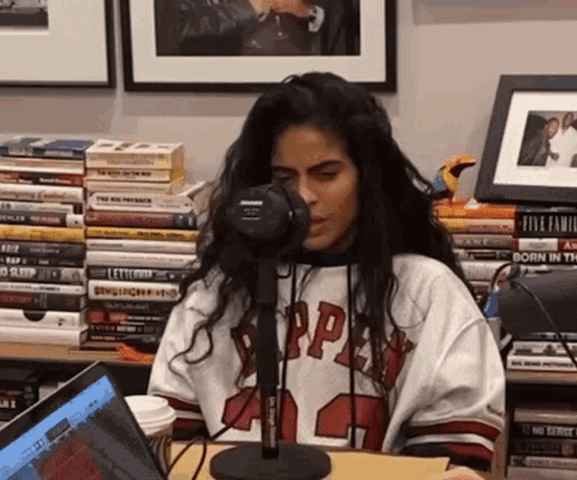 a woman wearing a jersey with the number 12 on it talks into a microphone
