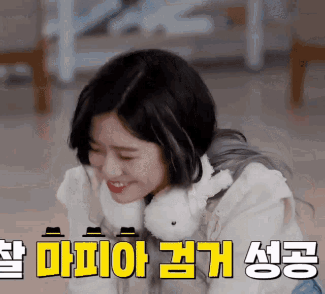 a woman is smiling in front of a sign that says ' korean ' on it