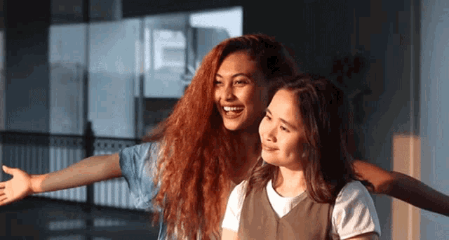 two young women are standing next to each other with their arms outstretched