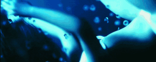 a person is swimming in a pool with bubbles in the water