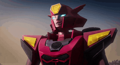 a close up of a red robot with yellow wings