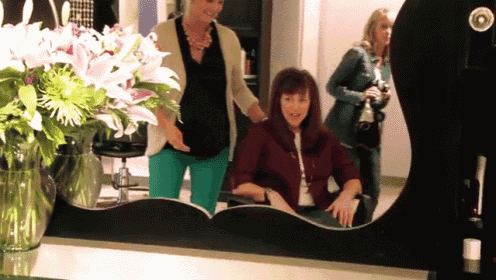 a woman is getting her hair done in front of a mirror in a salon