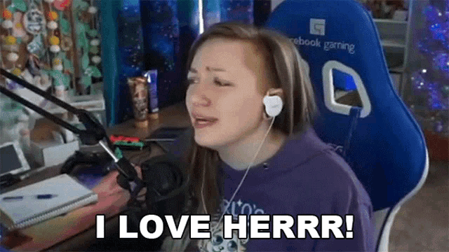 a woman wearing headphones is sitting in front of a microphone and saying i love herrr .