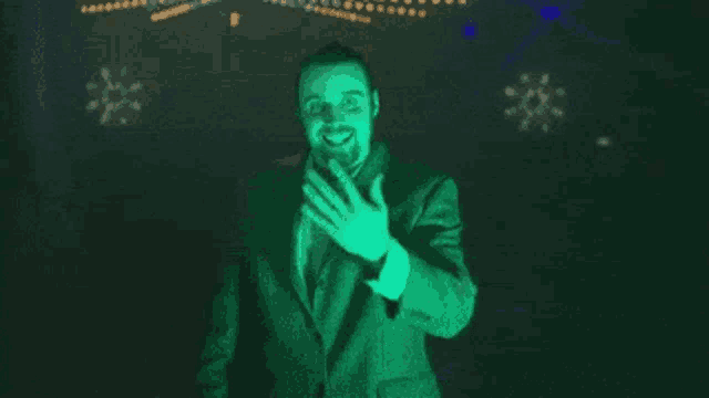 a man in a suit and tie is standing in front of a fireworks display in the dark .