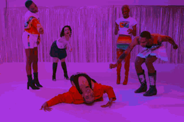 a group of people are dancing in a room with a green background