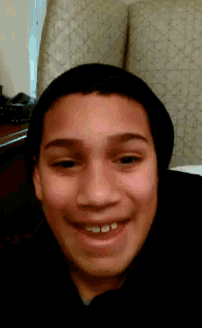 a young boy wearing a black hat is smiling