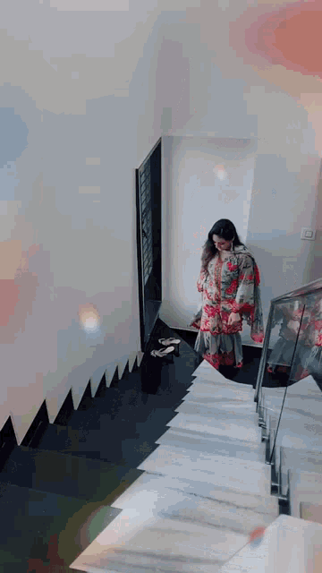 a woman is walking up a set of stairs in a house .