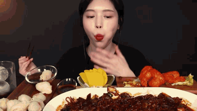 a woman with red lipstick is eating a plate of food with chopsticks