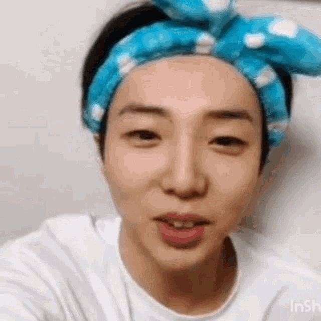 a close up of a person wearing a headband and a white shirt .