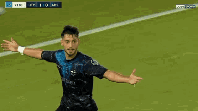 a soccer player wearing a jersey that says heineken is celebrating a goal