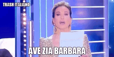 a woman in a gold dress is holding a piece of paper that says ave zia barbara on it