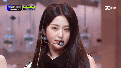a woman wearing a microphone on a stage with the words comeback on the bottom right