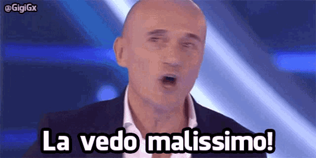 a bald man in a suit says la vedo malissimo on a blue background