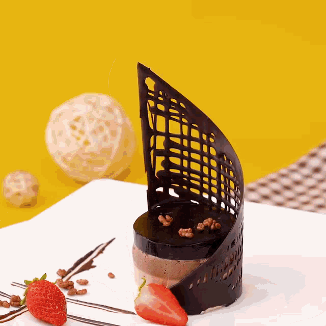 a white plate topped with a chocolate dessert with a strawberry on it