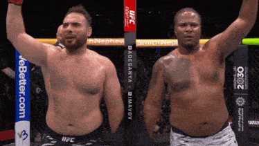 two men standing next to each other with one wearing a ufc shirt