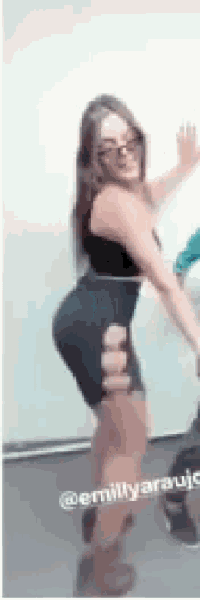 a woman in a black dress is dancing in a room with a man .