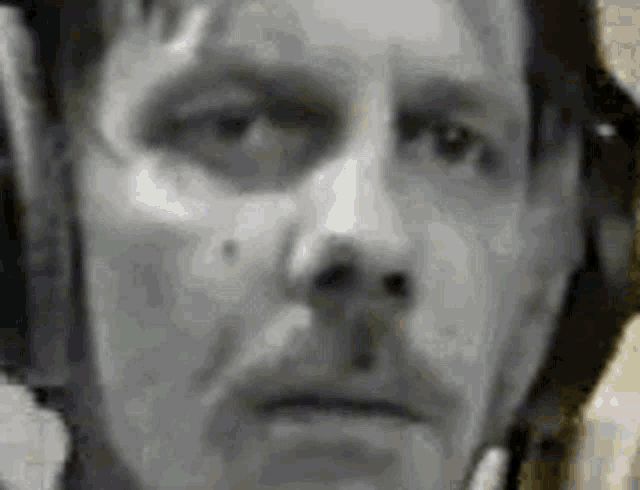 a black and white photo of a man wearing headphones and looking at the camera .