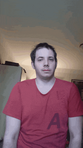 a man in a red shirt is making a face