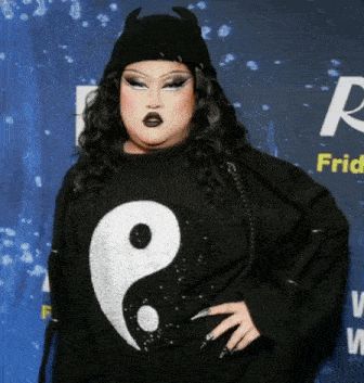 a woman in a black sweater with a yin yang symbol on it