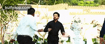 a man in a black shirt is dancing with a man in a white shirt ..