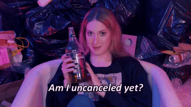 a woman sitting in a bathtub holding a bottle of alcohol with the words am i uncanceled yet written below her